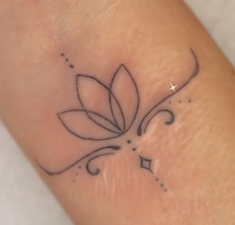 Fine-line lotus tattoo on wrist - Sisters Ink Tattoo Studio Da Nang